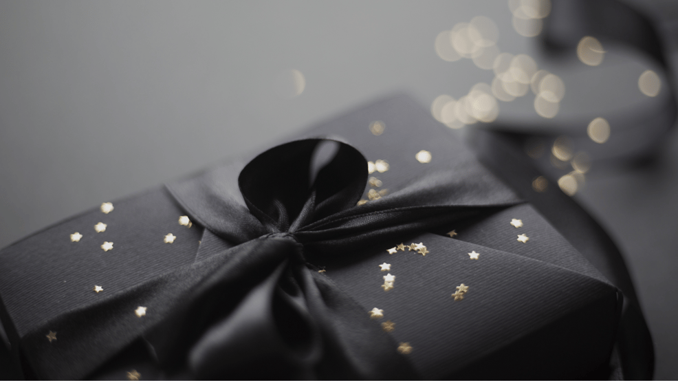 gift wrapped in black paper and ribbon with gold accents