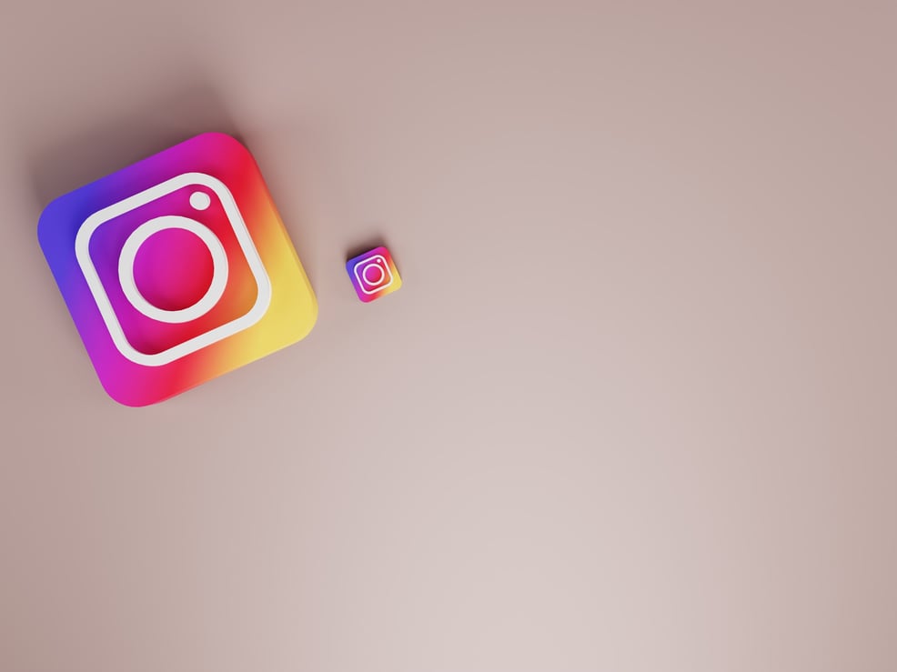 two instagram icons on a plain pink background