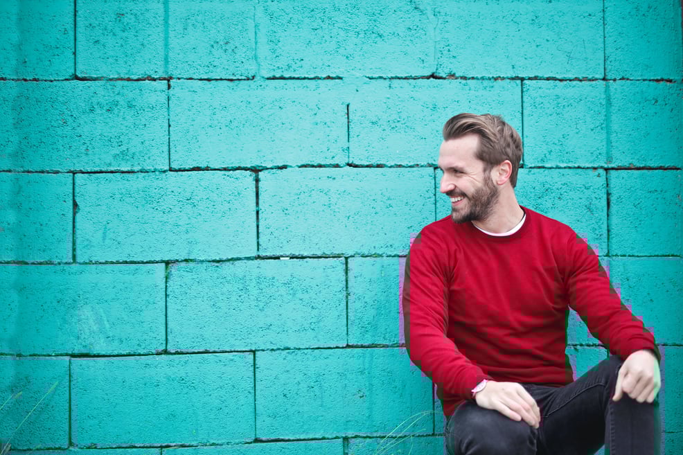 man-in-front-of-a-blue-brick-wall