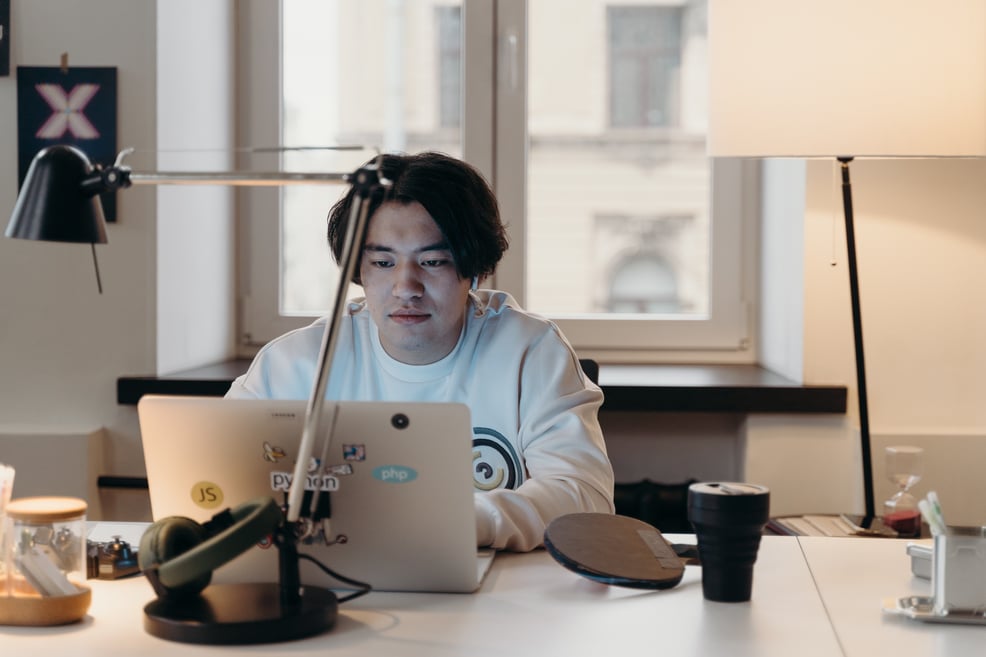 man-in-white-sweater-using-a-laptop