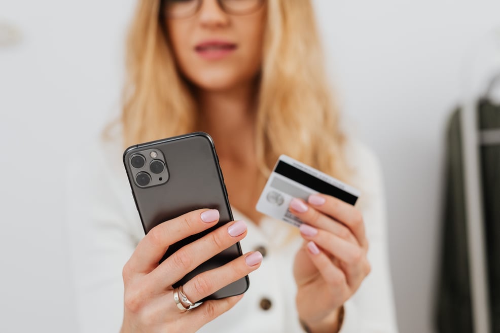 woman-holding-a-credit-card-and-smartphone