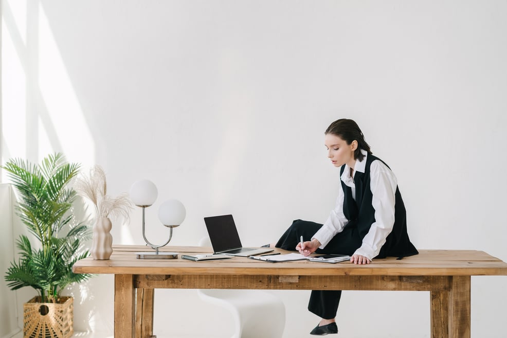 woman-sitting-on-desk-working