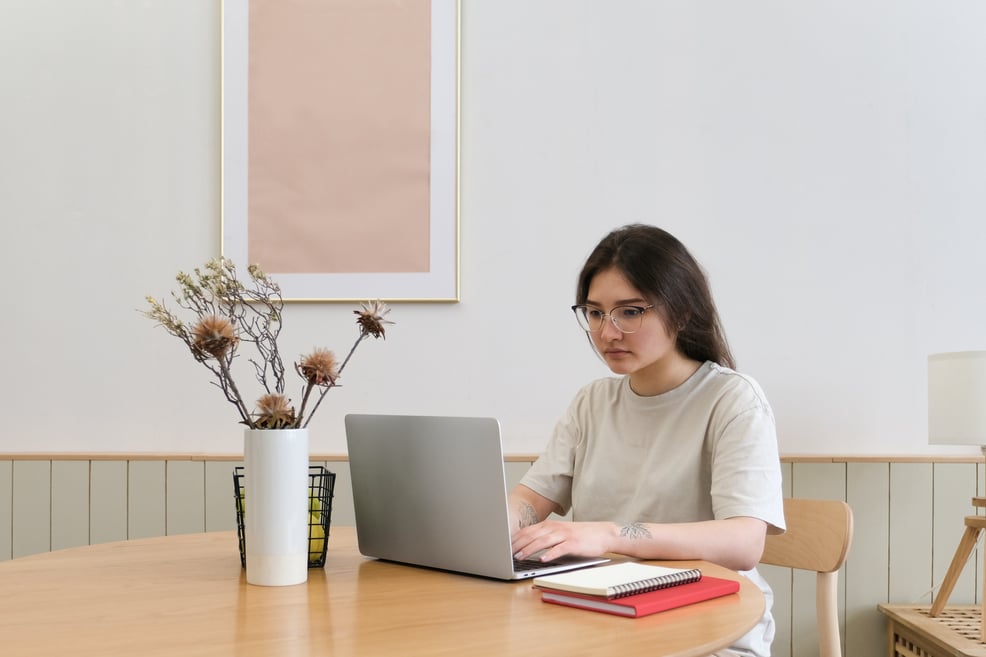 woman-working-on-her-laptop-near-a-vase