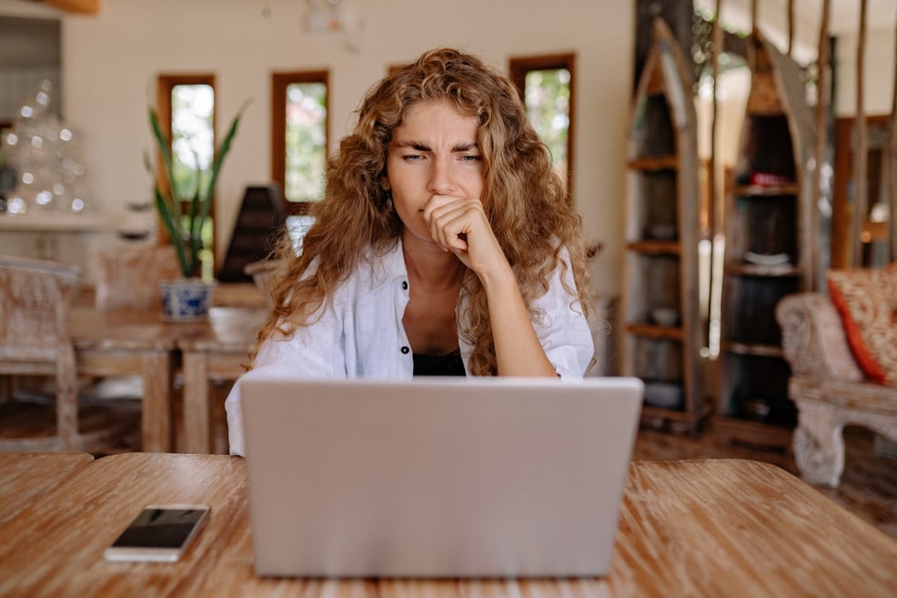 woman-looking-serious-while-using-laptop
